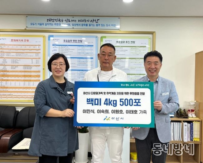 가족대표로 백미 전달식에 참석한 이민식 씨(중앙)가 기념촬영을 하고 있다.