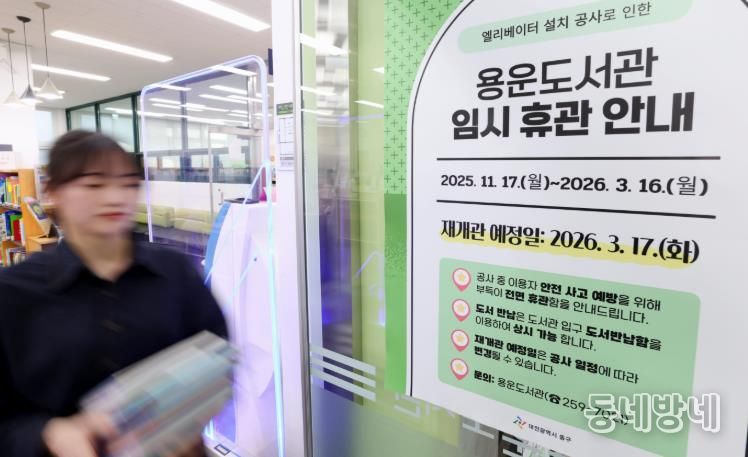 용운도서관 직원들이 휴관 안내문을 부착하고 있다