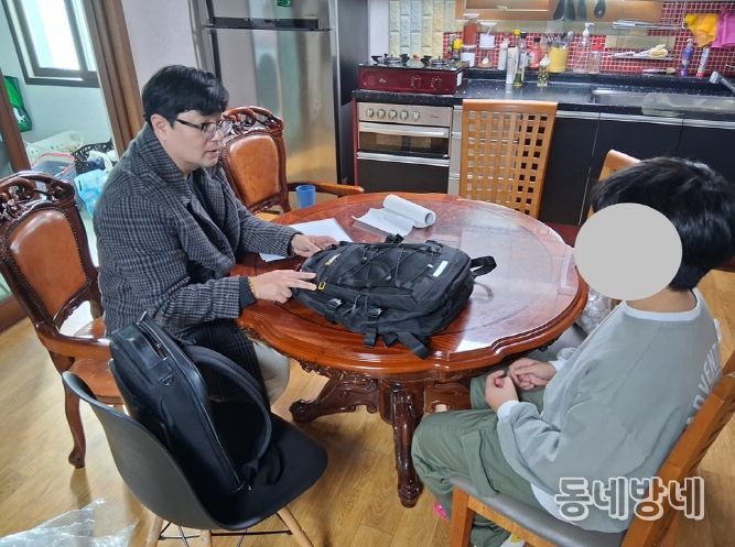 신안군 드림스타트 아동통합사례관리사가 가정 방문하여 아동에게 책가방을 전달하고 있다.